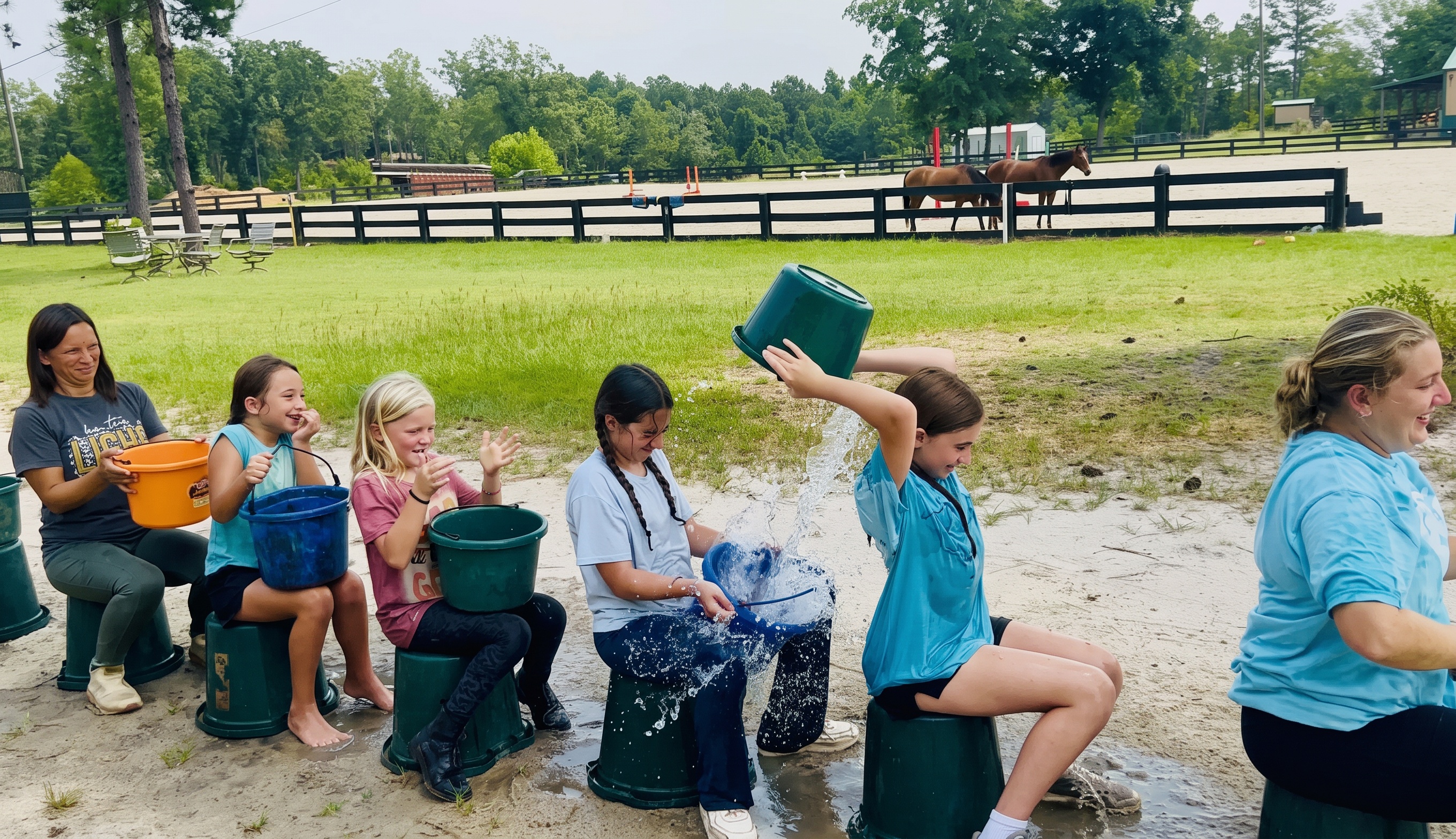Kids mid-laugh during water bucket games with the arena behind them